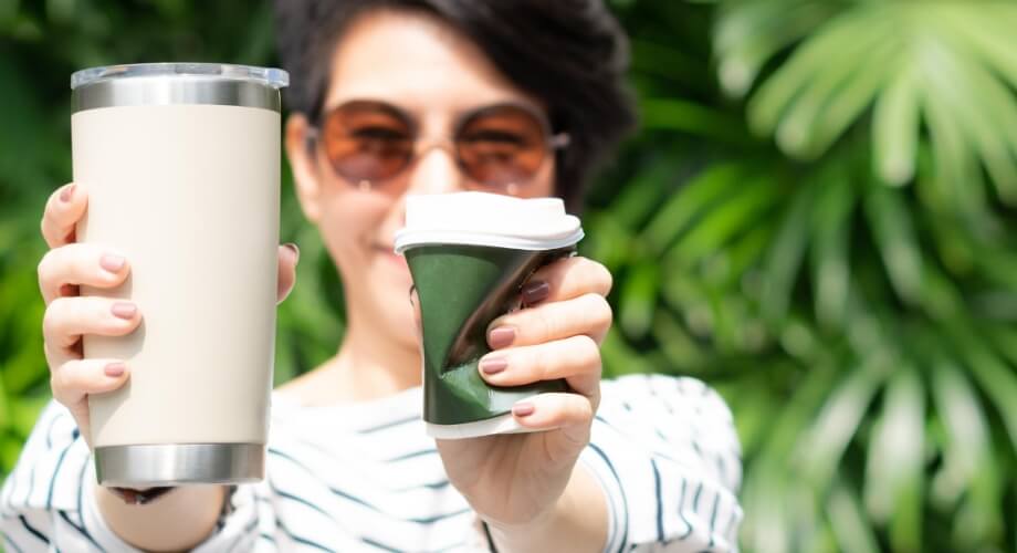 Woman holding tumbler and coffee cup